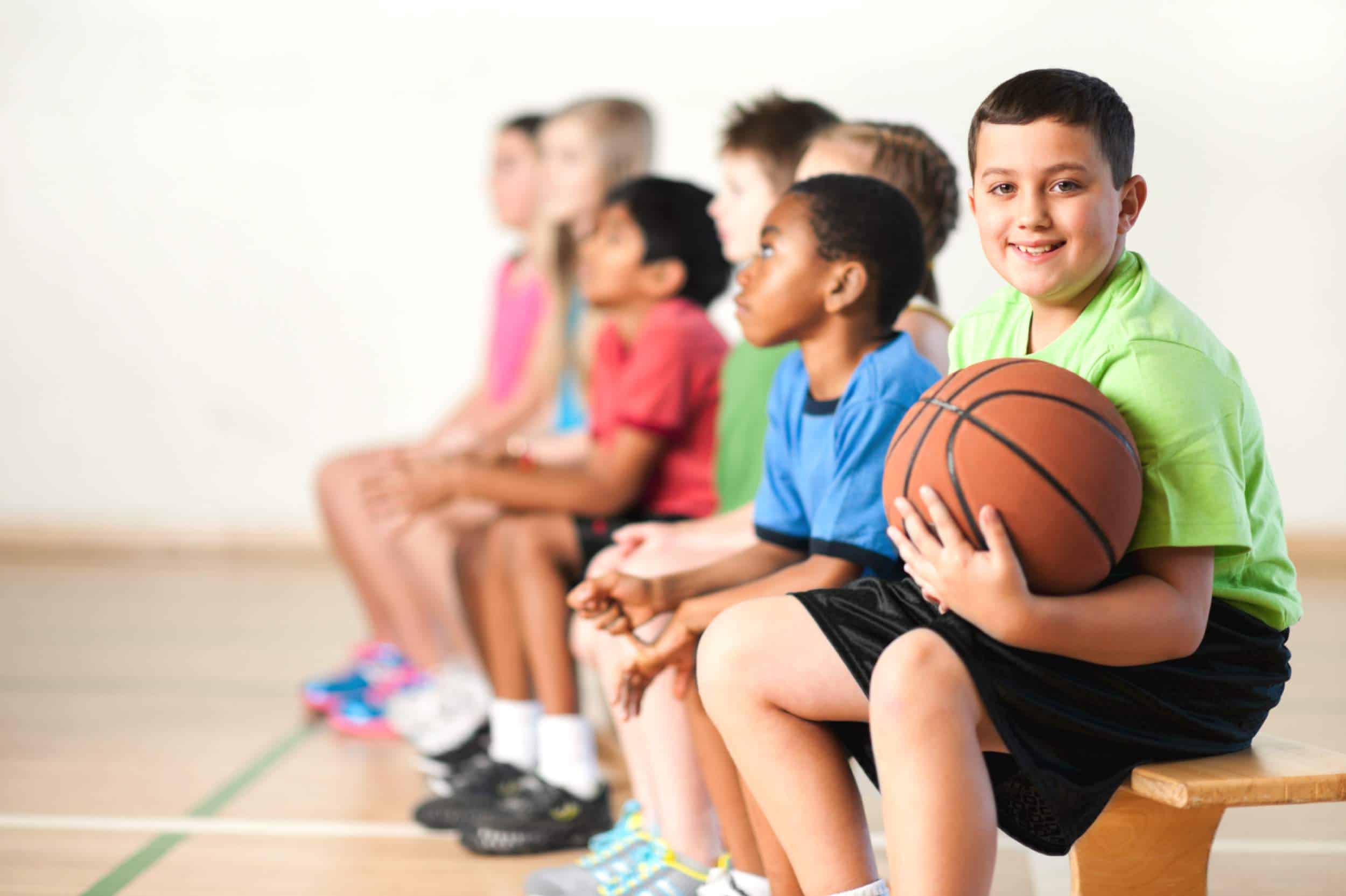 jeune obèse dans un gymnase avec ballon de basket