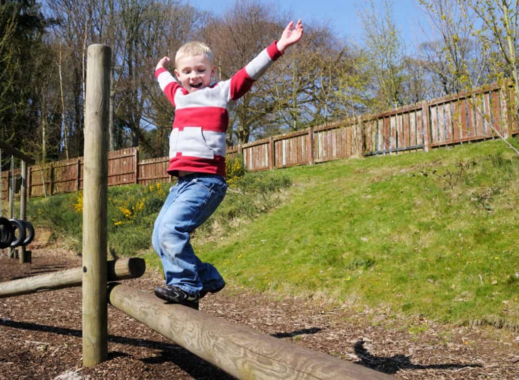 enfant profite de l'extérieur sur un morceau de bois 